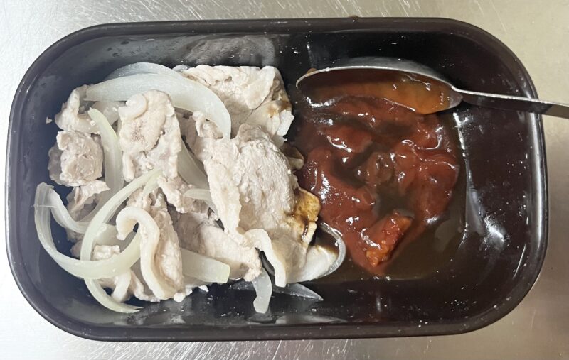 レンチン後の豚肉と玉ねぎにケチャップやコチュジャンなどのBBQソースの調味料を投入している様子。