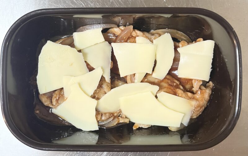 タッカルビ風ソースと豚肉を混ぜた後、とろけるスライスチーズを乗せて、再び電子レンジで1分加熱する前の写真。