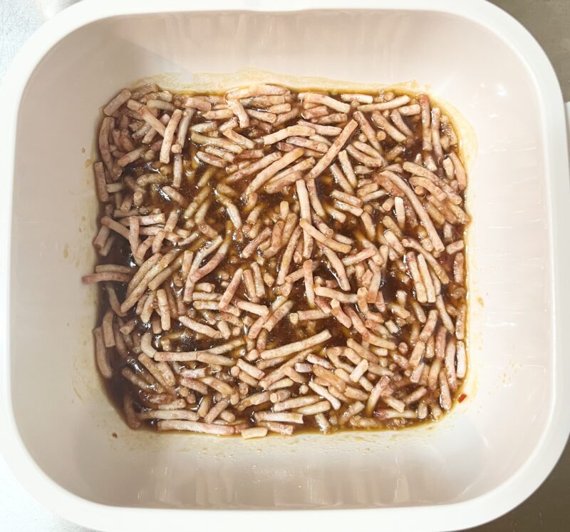 耐熱容器に水、醤油、豆板醤、豚ひき肉など調味料を入れた写真