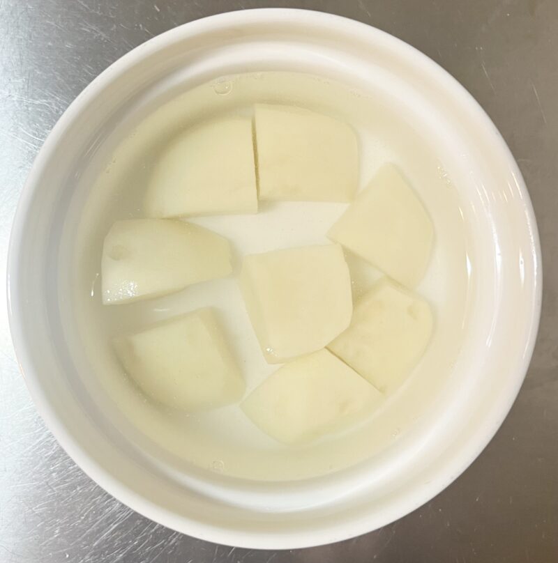 じゃがいもを切り、水にさらしている様子