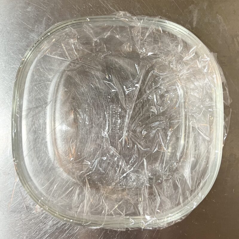 耐熱容器にラップをしいた写真。この中に調味料やさつまいもを混ぜた生地を流し入れる予定。