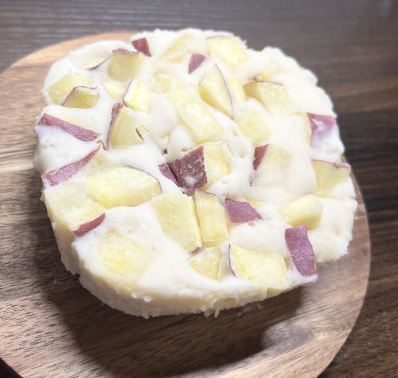 ラップごと耐熱容器から取り出し、裏返して皿に盛り付けたさつまいも蒸しパン。もっちりした断面と、ゴロゴロ入ったさつまいものホクホク感が伝わる写真。