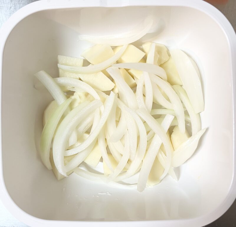 じゃがいもと玉ねぎを耐熱容器(グルラボ)に入れ、水(分量外)を加えて電子レンジで4分加熱する前の様子。