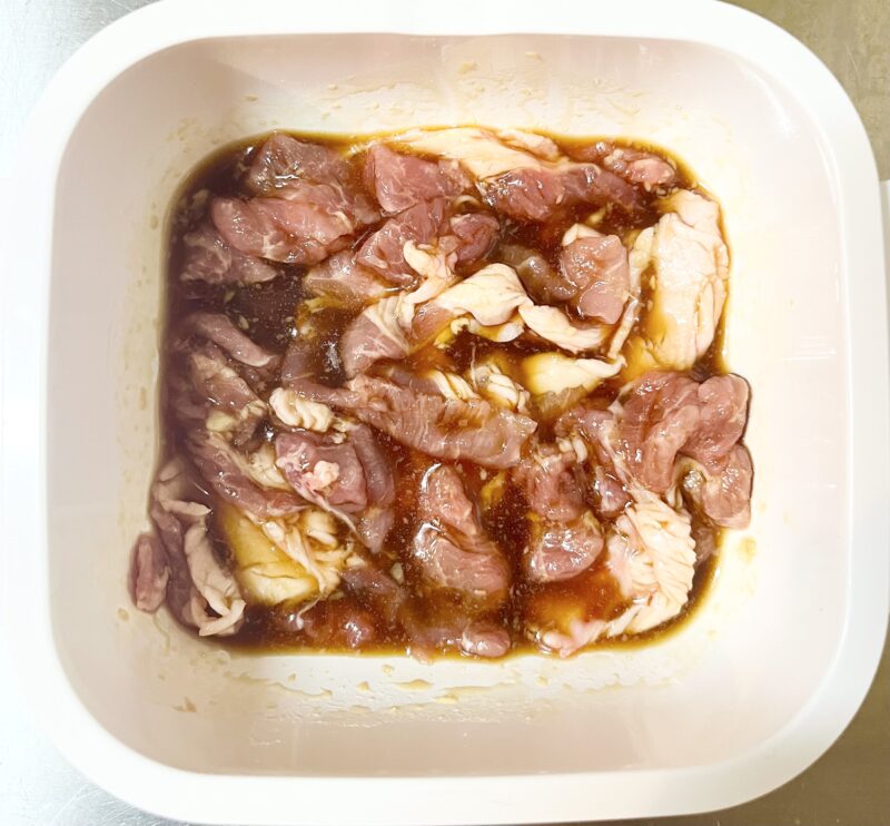 耐熱容器の中で豚こま肉と生姜焼きのタレをしっかり混ぜ合わせた様子