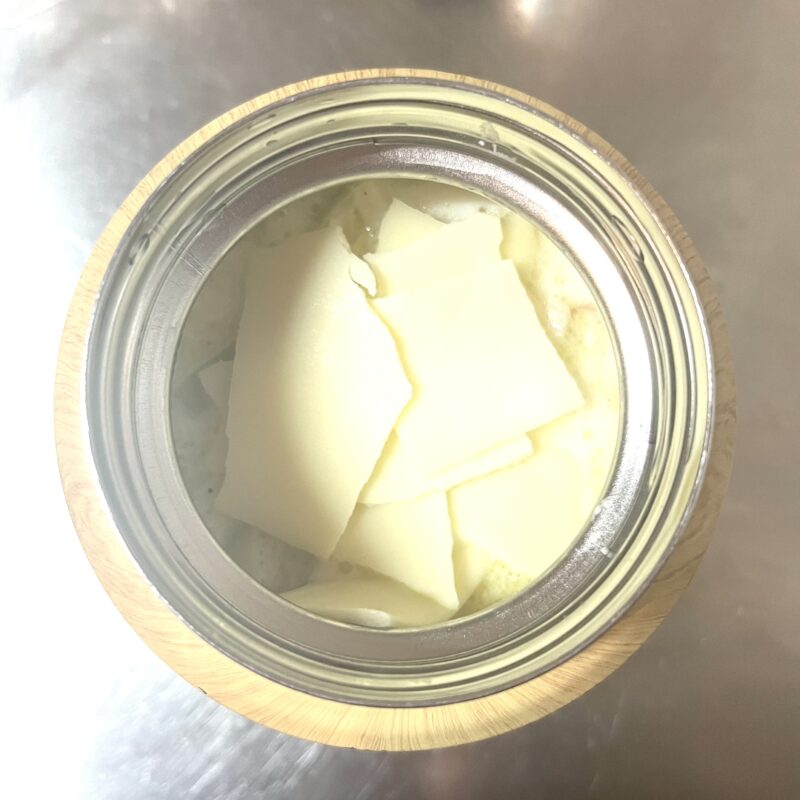 マカロニがはいったスープジャーに熱々のスープとチーズを入れている様子。