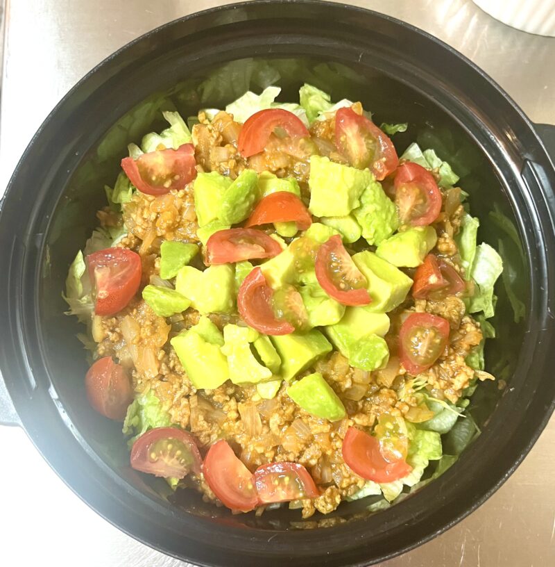 どんぶりにご飯、レタス、ひき肉、トマト、アボカドを盛り付けた、栄養たっぷりなタコライス