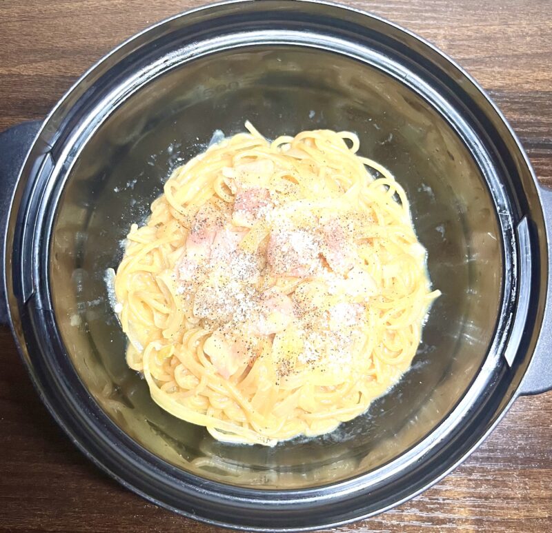 味噌と粉チーズで牛乳なしでも濃厚！レンジで作るカルボナーラのアップ。とろりとしたソースと、具材の旨みが詰まった様子。仕上げの粉チーズとブラックペッパーが食欲をそそる。