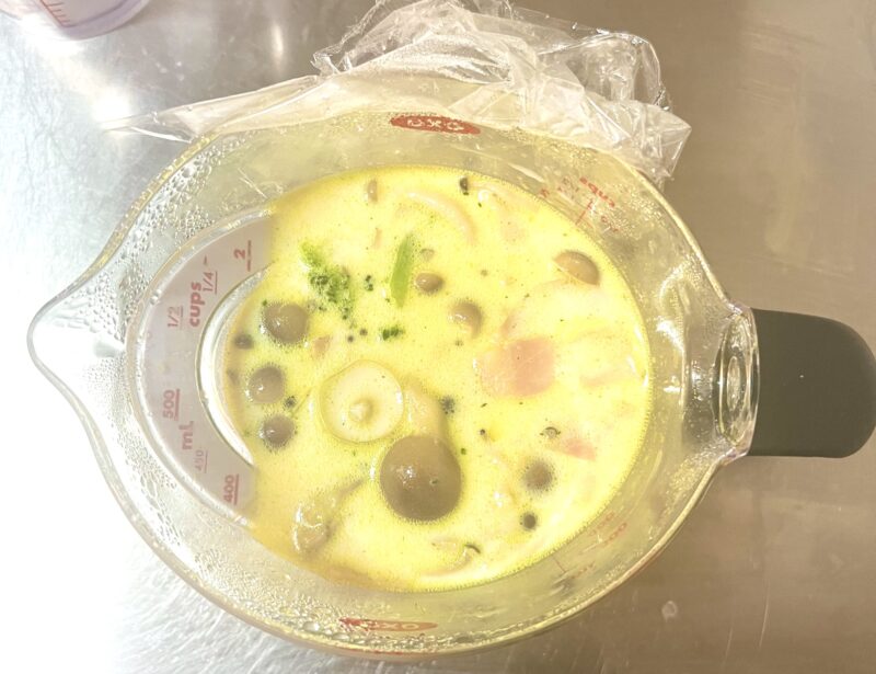 具材やスープに牛乳を加えて、追加で電子レンジで加熱する様子。