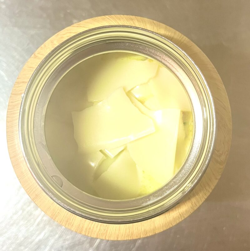 熱々のミルクカレースープの上にとろけるスライスチーズをちぎってのせた様子。