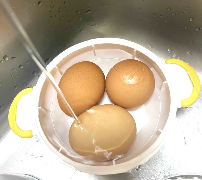 加熱が終わった卵を水道水で一気に冷ましている様子