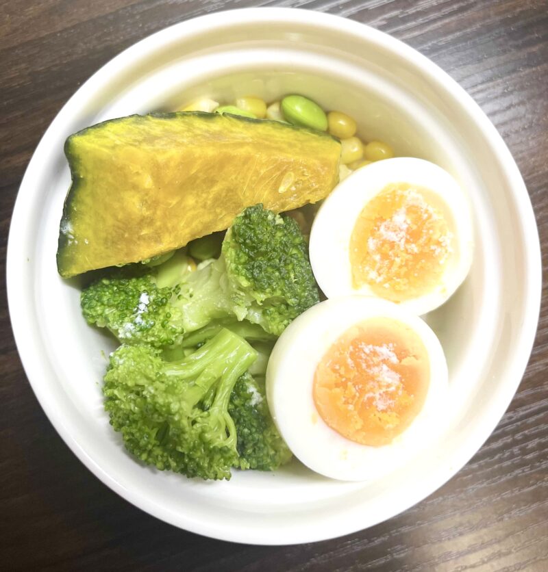 レンジでツルンと綺麗に剥けたゆで卵をサラダにトッピングした様子